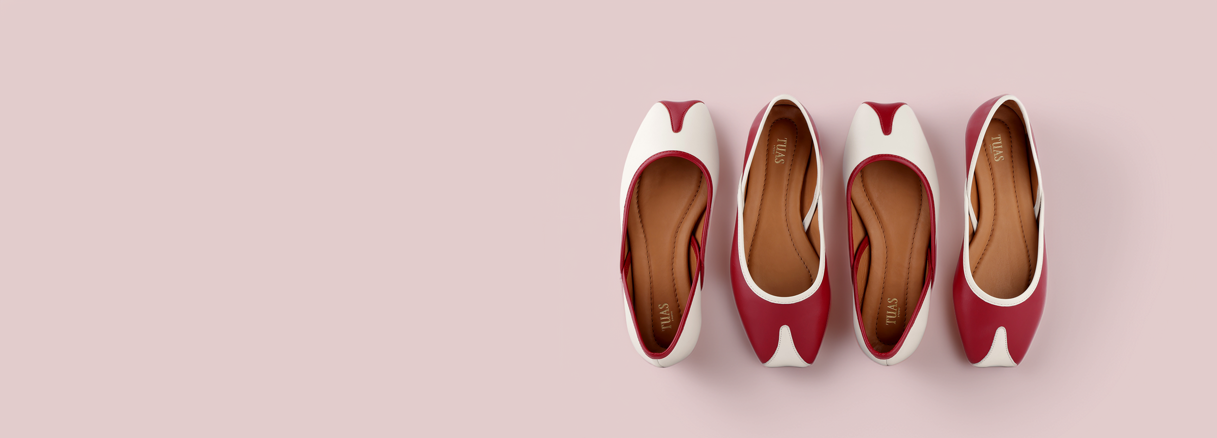 Four pairs of red and white shoes arranged in a row on a pink background