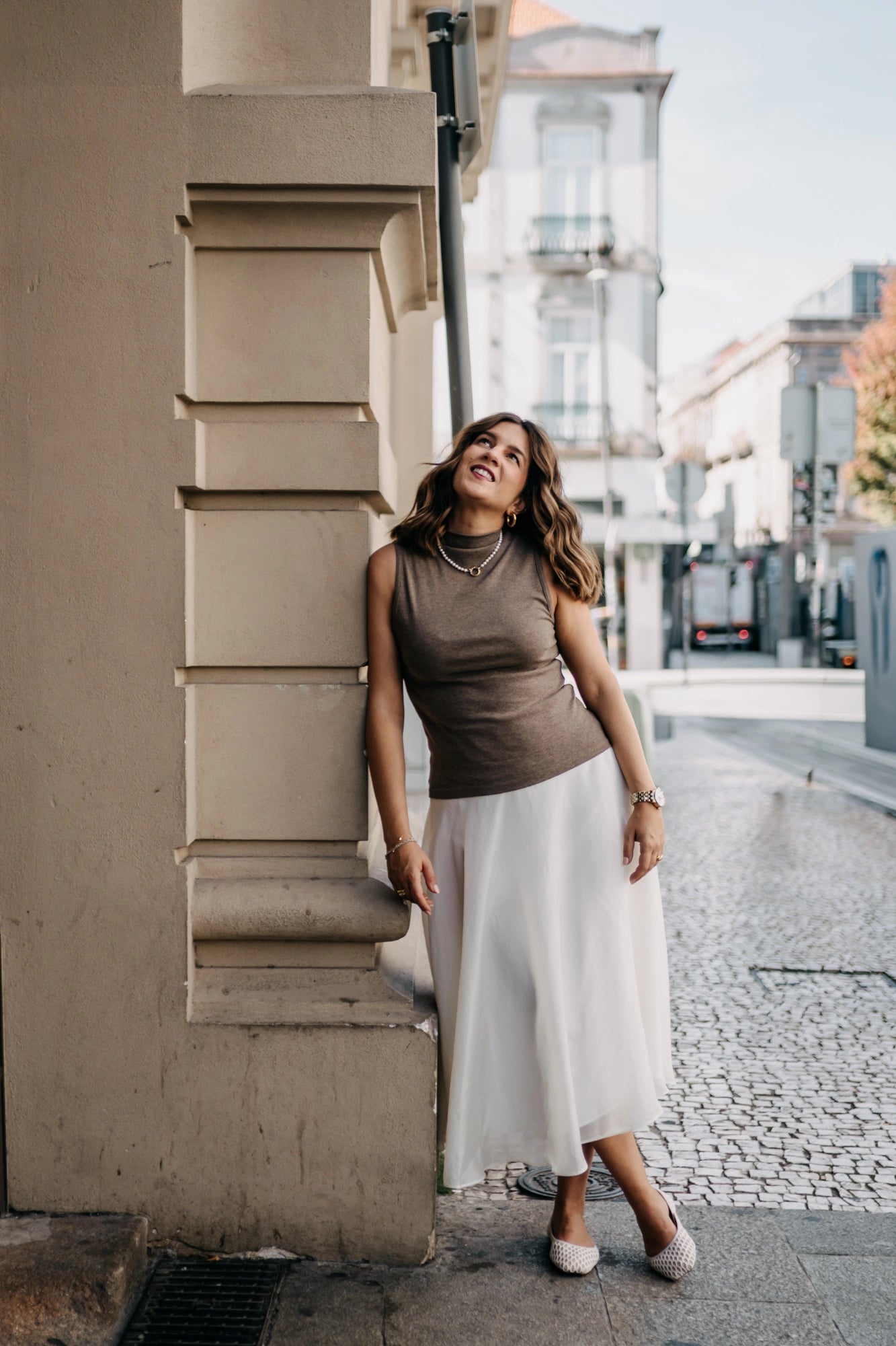 Woman leaning against a building on a city street