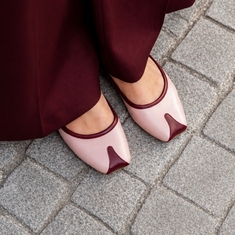Pink shoes with a unique design worn on a gray pavement