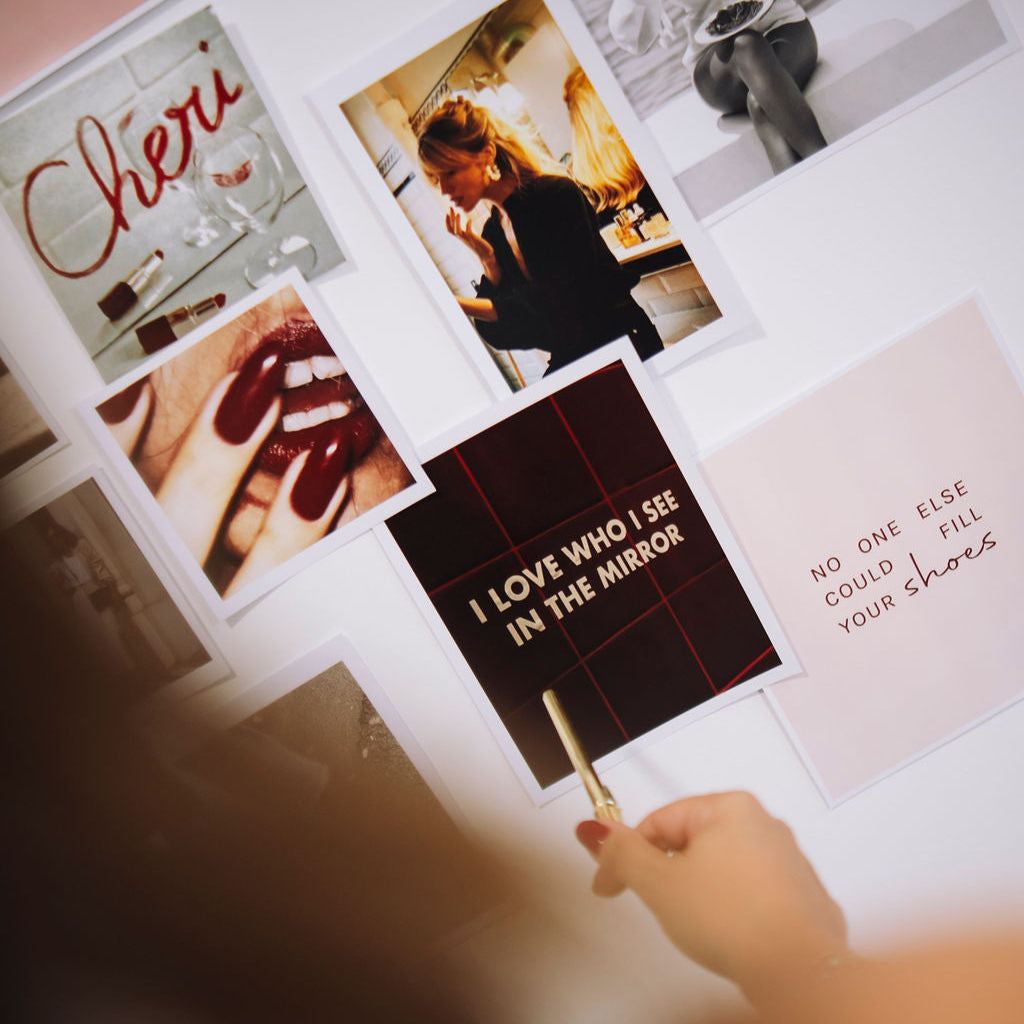 Person holding a sign with text in front of a display of photos and posters.