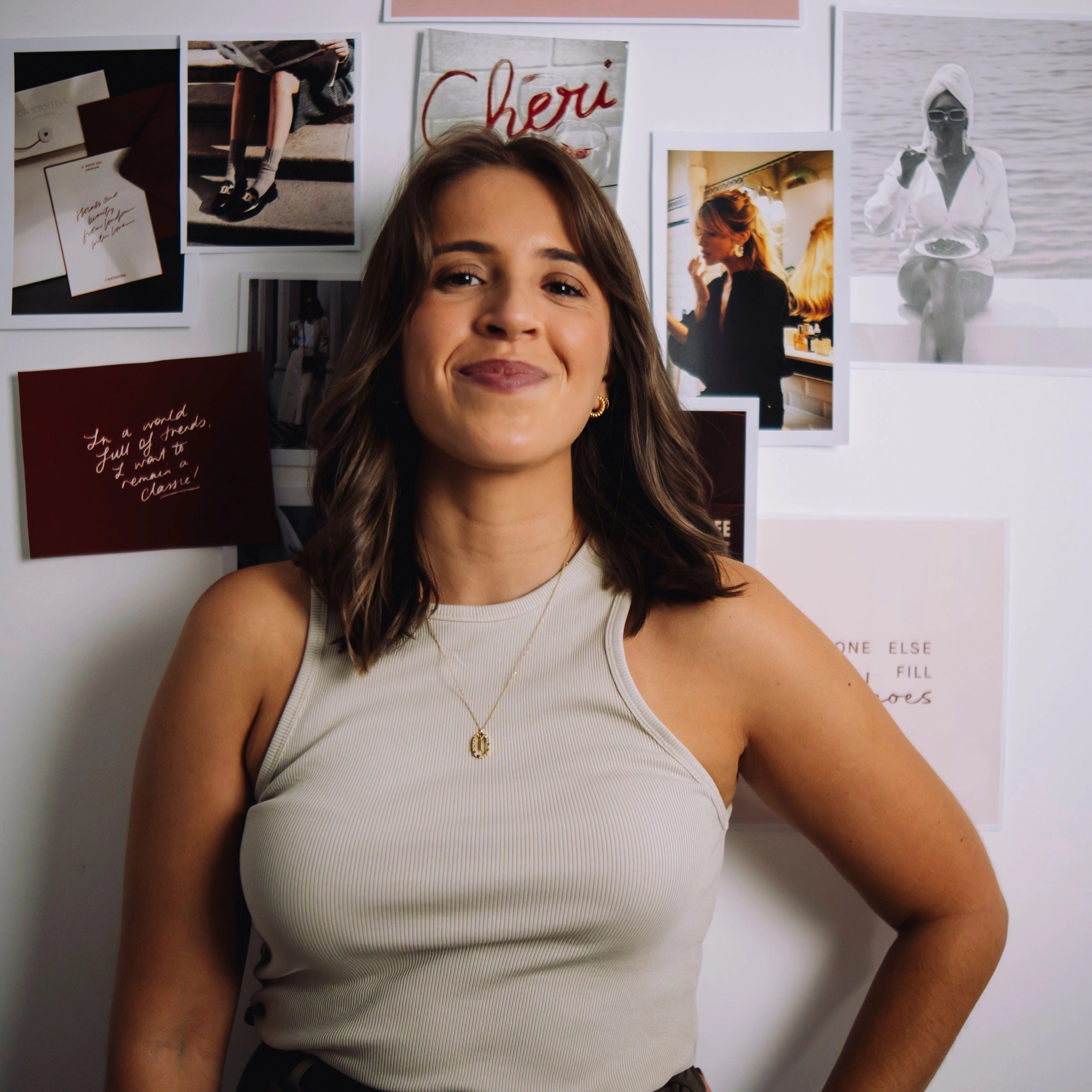 Woman standing in front of a wall with various photos and text