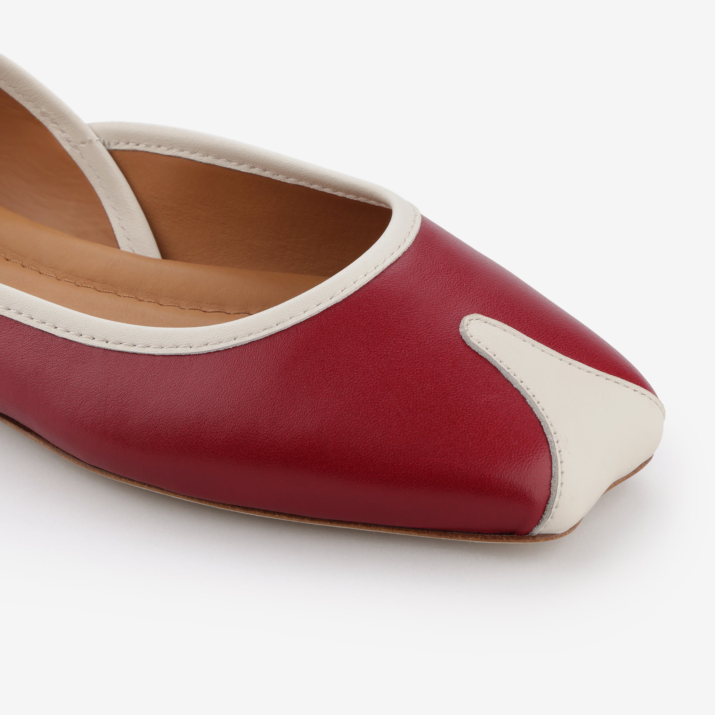 TUAS Julia winery red flat shoe with white accents on a white background