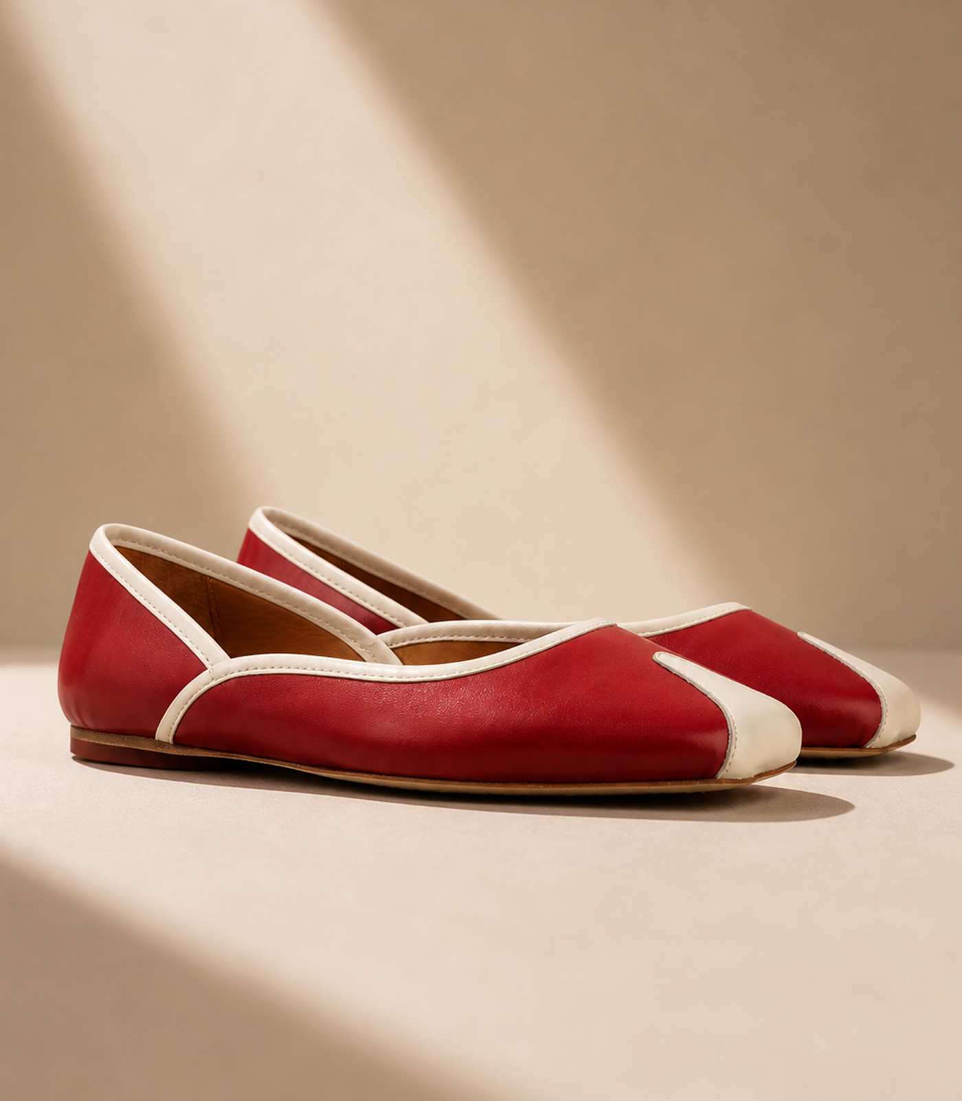 Red flats with white accents on a beige background